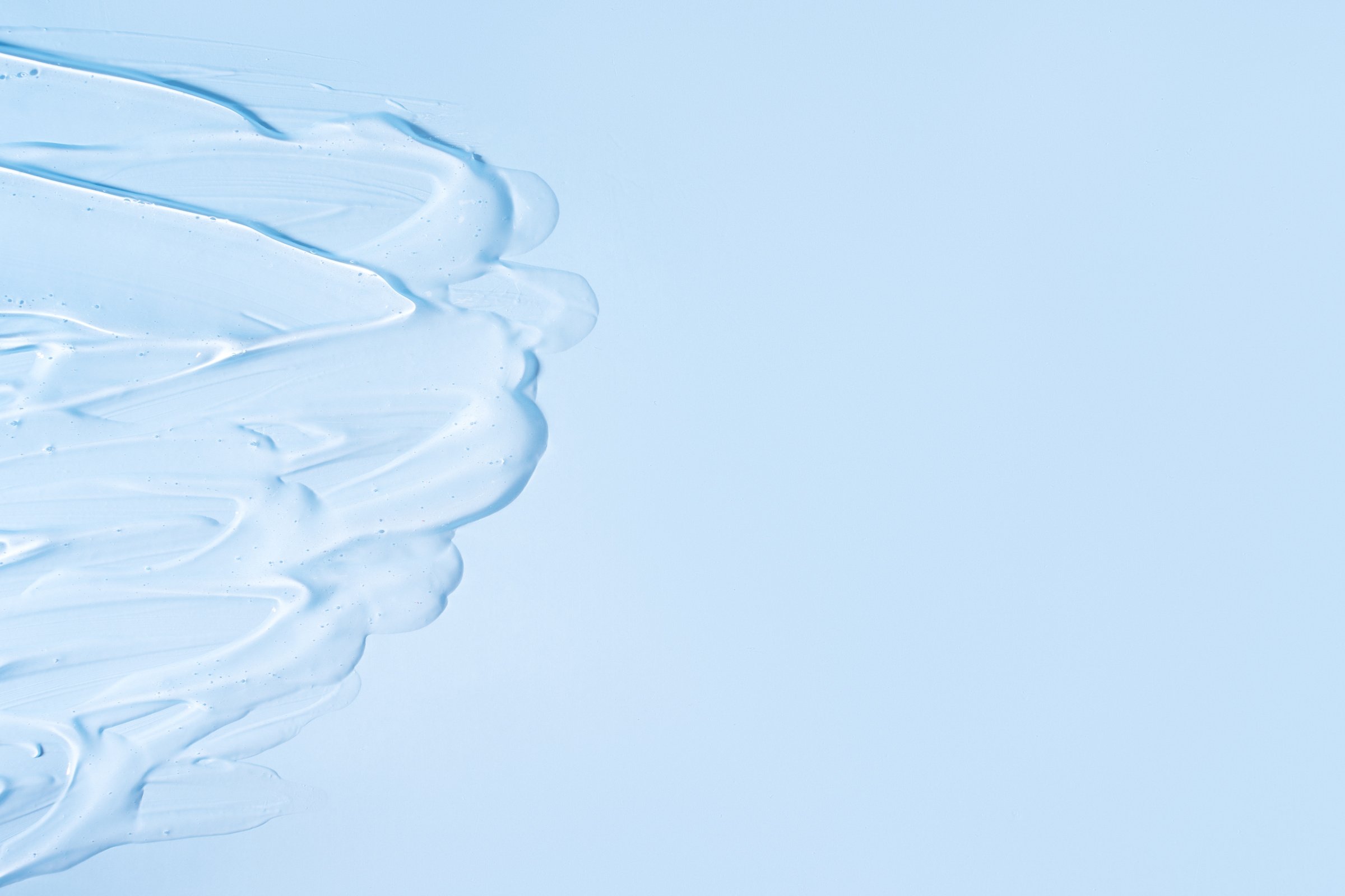 Transparent Cream Is Smeared on Blue Background